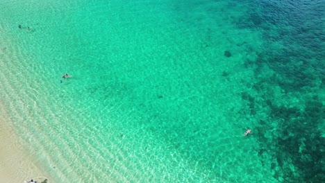 Aerial-descending-on-coral-reef-and-Waimea-beach,-Hawaii