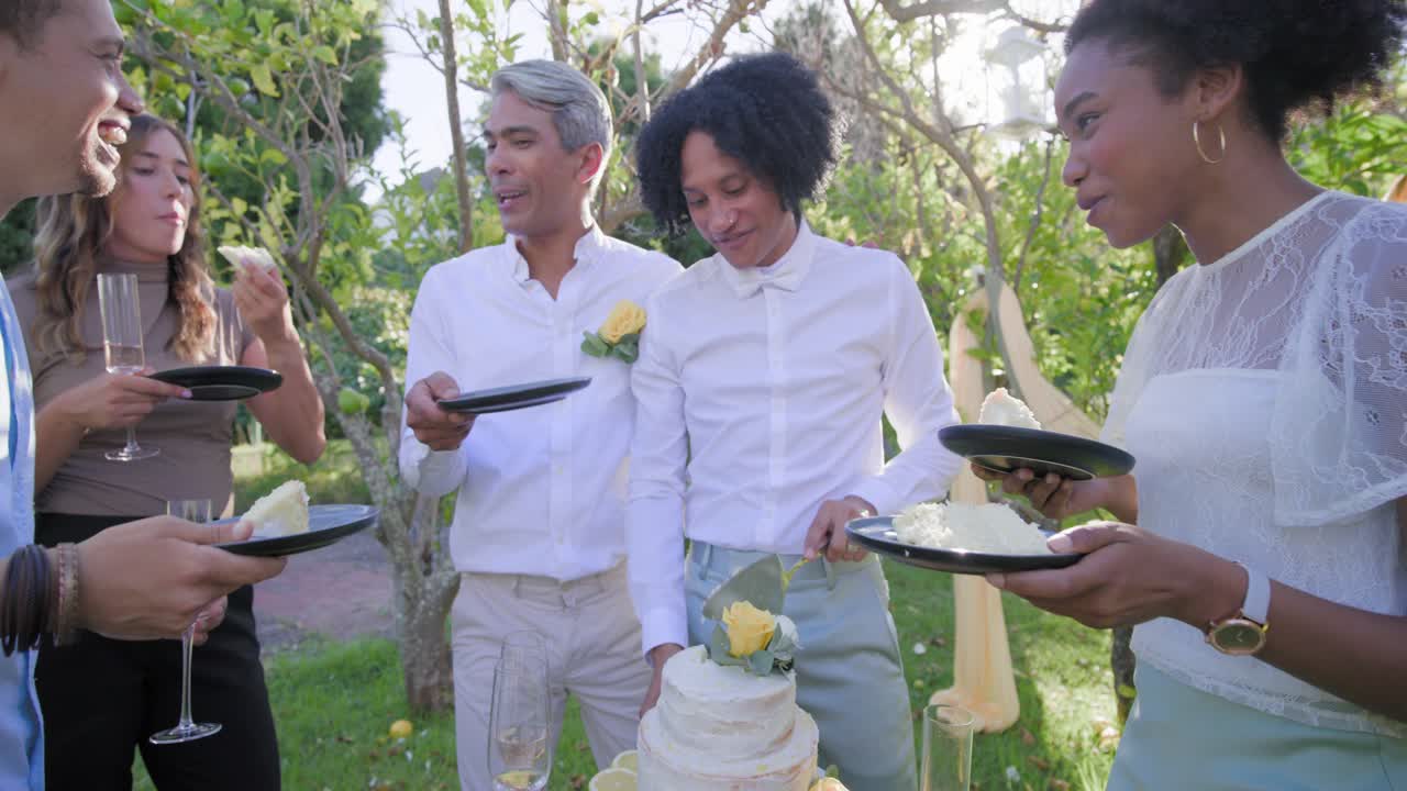 Vertical video: Cutting bowtie man grabbing server and serving cake slices to celebrate in garden