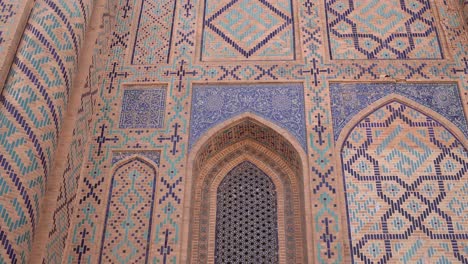 detailed tling and islamic artwork on arched windows and doorways of historic mosque in samarkand, uzbekistan along the historic silk road