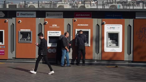 personas que usan cajeros automáticos en la ciudad