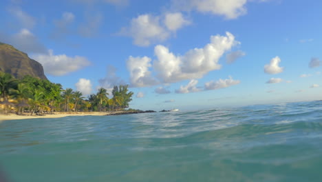 Bathing-in-clear-blue-ocean-with-view-to-tropical-beach