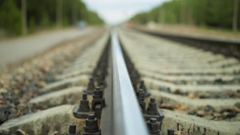 a close-up view of a railroad track stretching into the distance, the video focuses on the rail and its fastenings, with the background beautifully blurred