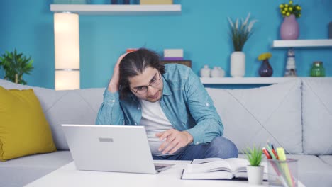 joven agresivo y preocupado trabajando en una computadora portátil.
