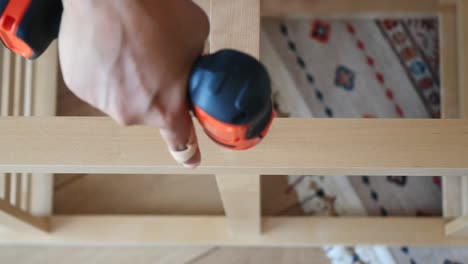 man assembling a chair with a screwdriver