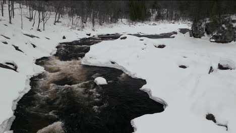 aerial scenic drone backward motion canadian wilderness mid winter near north quebec stoneham ski resort of frozen over sautaurski river downstream