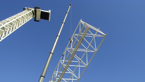 guindaste sendo construído em seções por guindaste menor
