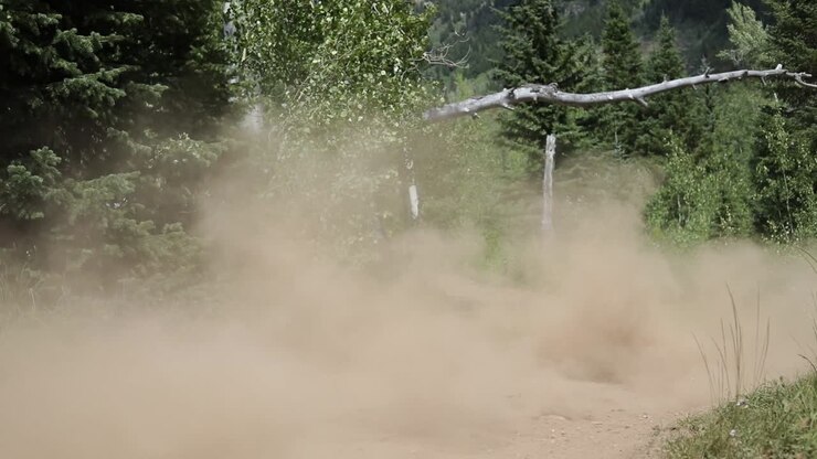 Slow motion shot of an ATV Rider driving his quad off of a small jump and getting a little bit of air time
