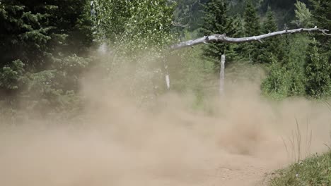 slow motion shot of an atv rider driving his quad off of a small jump and getting a little bit of air time