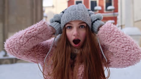 young woman in winter clothes smiling happily in the snow