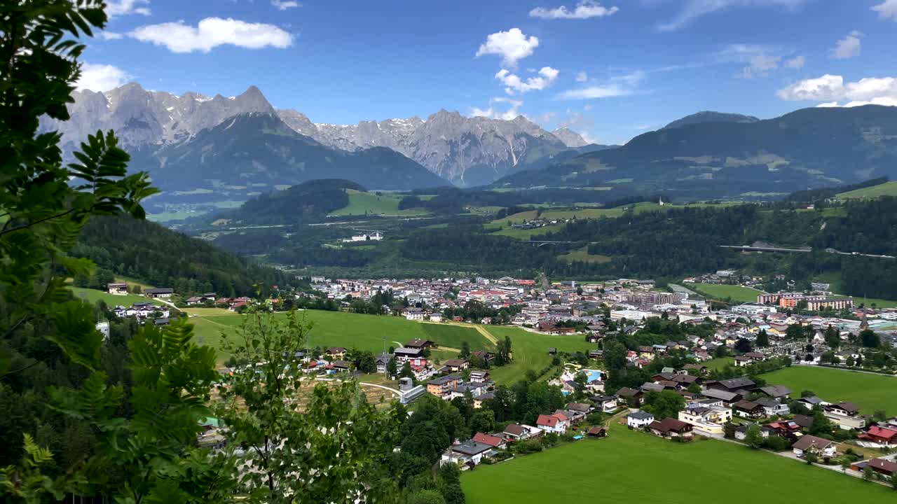 toma panorámica del pintoresco paisaje urbano rural con cordillera en el fondo durante el día soleado - bischofshofen,austria