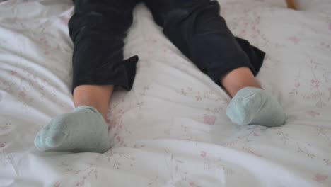 child's legs and feet in socks on a bed with floral patterned bedding