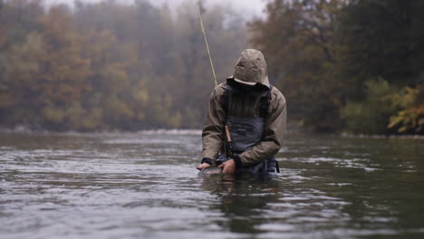 man fly fishing in a river