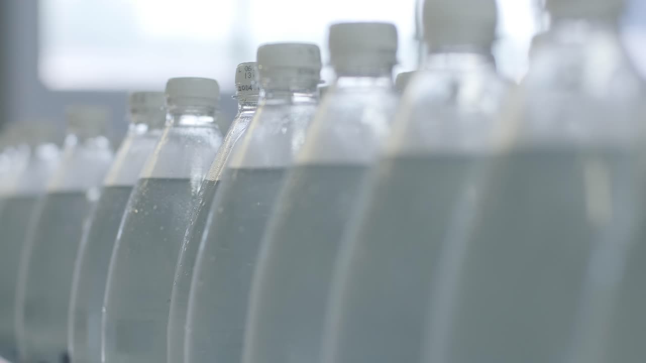 cinta transportadora con botellas de agua potable en una planta de bebidas moderna