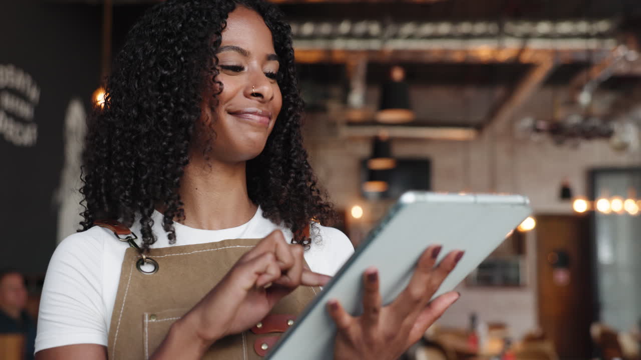 Young Black Woman Working on Digital Tablet in Cafe