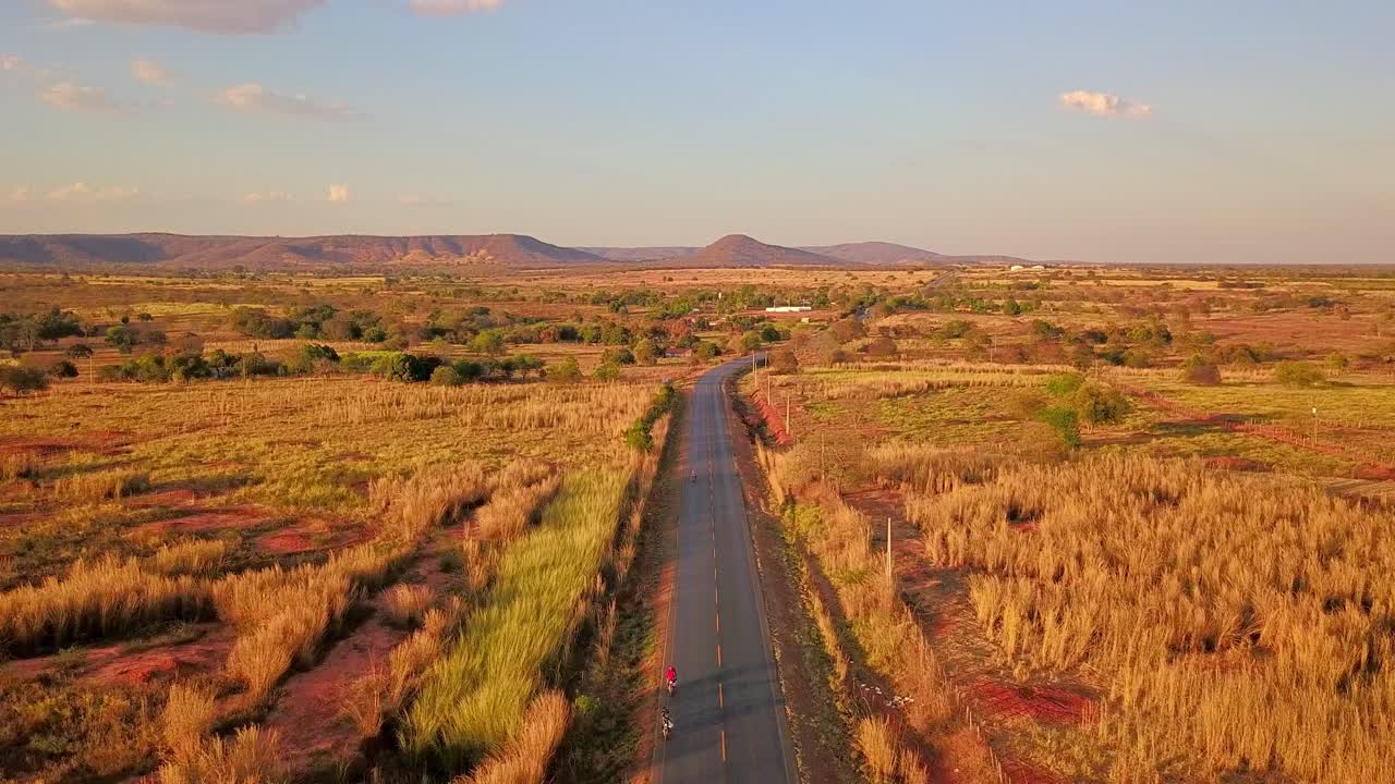 bella antena cinematográfica sobre una carretera solitaria que pasa por los campos secos y estériles de la bahia rural, brasil