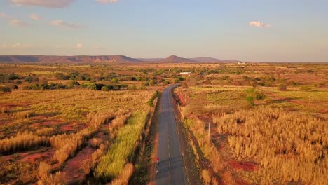 beautiful cinematic aerial over a lone road passing through the barren dry fields of rural bahia, brazil