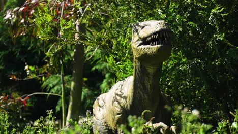 reptile dinosaur model with moving mouth and head is hiding under a bush looking for his prey scary terrifying