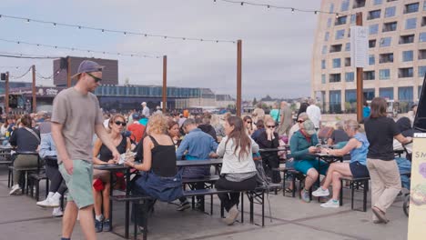people sit near table at reffen street food market event, copenhagen