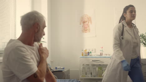 elderly man holding shoulder after vaccine in clinic closeup. prevention concept