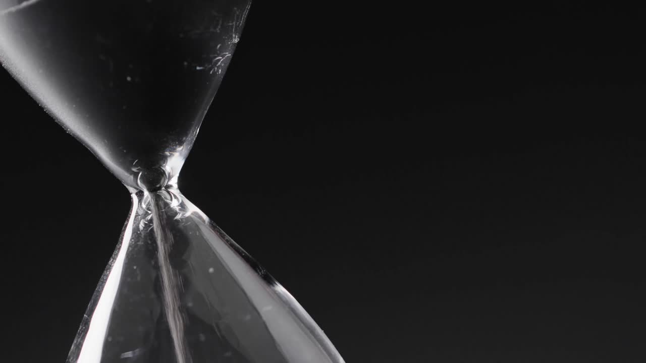 Video di clessidra con sabbia che scorre, spazio per il testo su sfondo nero