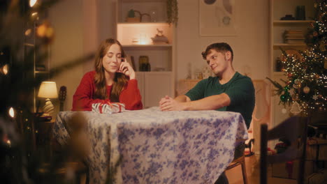 man giving christmas gift to girlfriend at home