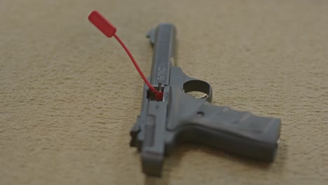 hand placing chamber flag in empty pistol, indicating the handgun is cleared