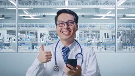 Close Up Of Asian Male Doctor With Stethoscope Using Smartphone And Showing Thumbs Up Gesture In Laboratory