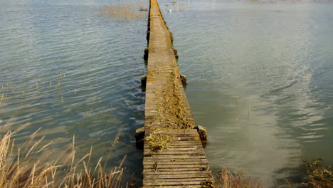 tiro ancho de un largo muelle de madera con escombros de inundación en la parte superior