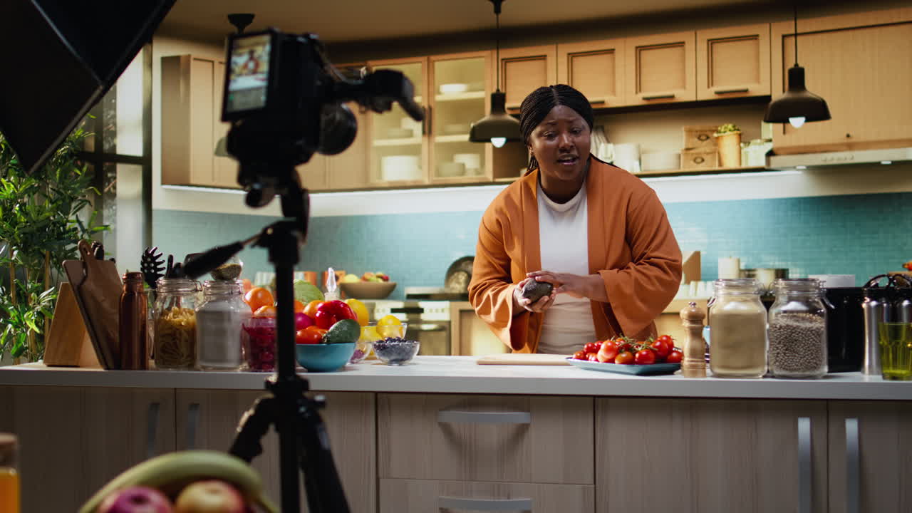 Food vlogger, donna di colore, che verifica le impostazioni della fotocamera prima di girare un video