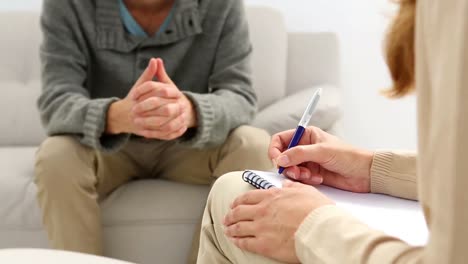 young man sitting on sofa talking to his therapist