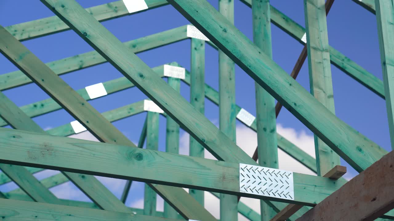 Close-up of timber roof truss joints and metal plates in new construction project
