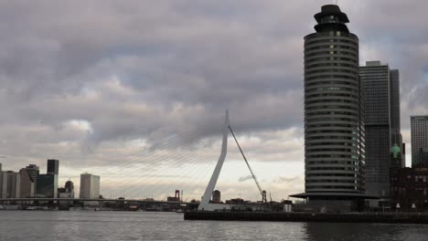 on a moody, cloudy day in the dutch city of rotterdam some water taxis cross the river!