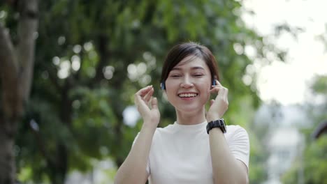 woman walking and listening to music with wireless headphones