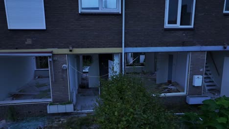 Aerial-panning-footage,-abandoned-and-badly-damaged-terraced-houses