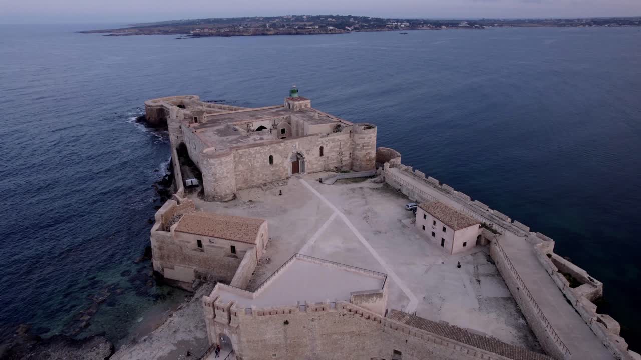 ascenso aéreo inclinado hacia abajo castillo isla de ortigia al anochecer, sicilia italia