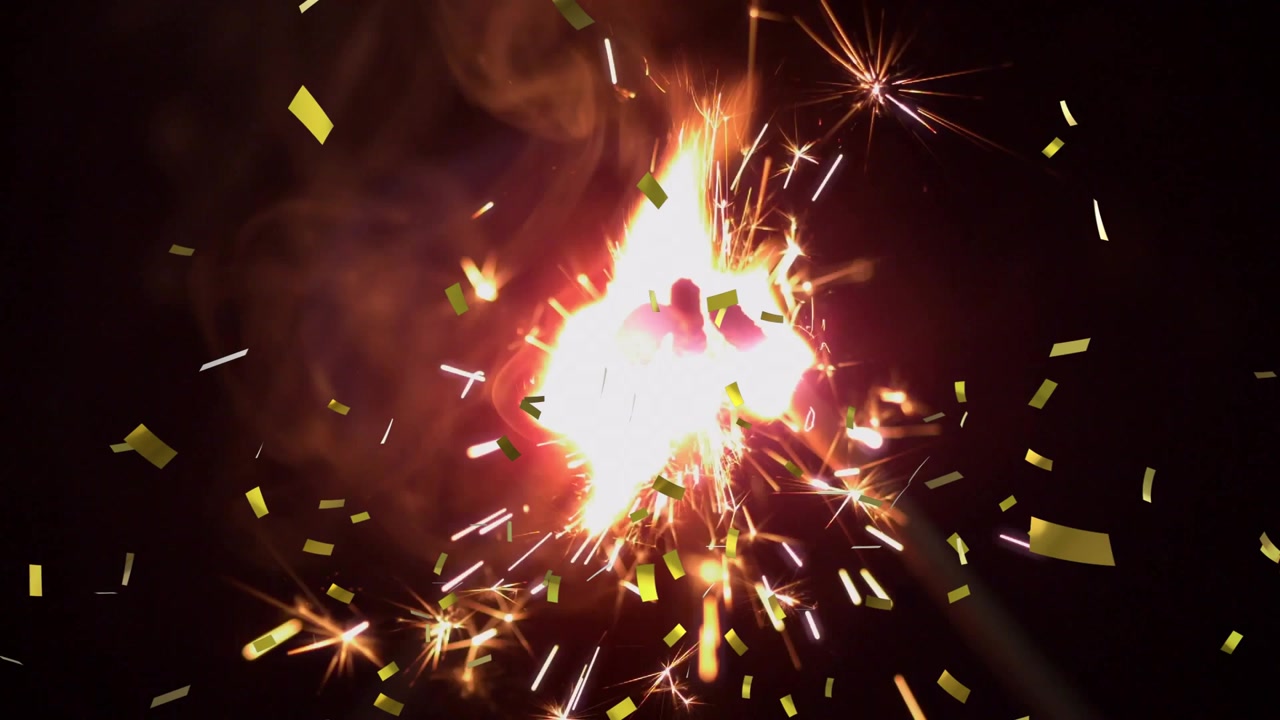 Sparkler being lit by hand, handheld sparkler emitting sparks and confetti, creating festive glow
