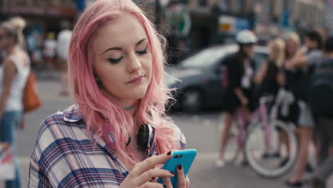 slow motion portrait of caucasian girl with pink hair using smart phone