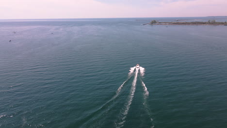 Vista-Aérea-De-Lancha-Motora-Navegando-Rápido-A-Alta-Velocidad-En-Aguas-Turquesas-Del-Lago-Erie,-Zona-Costera-De-Nickel-Beach-Ontario-Canada-En-Verano,-Náutica-Y-Paisaje-Marino