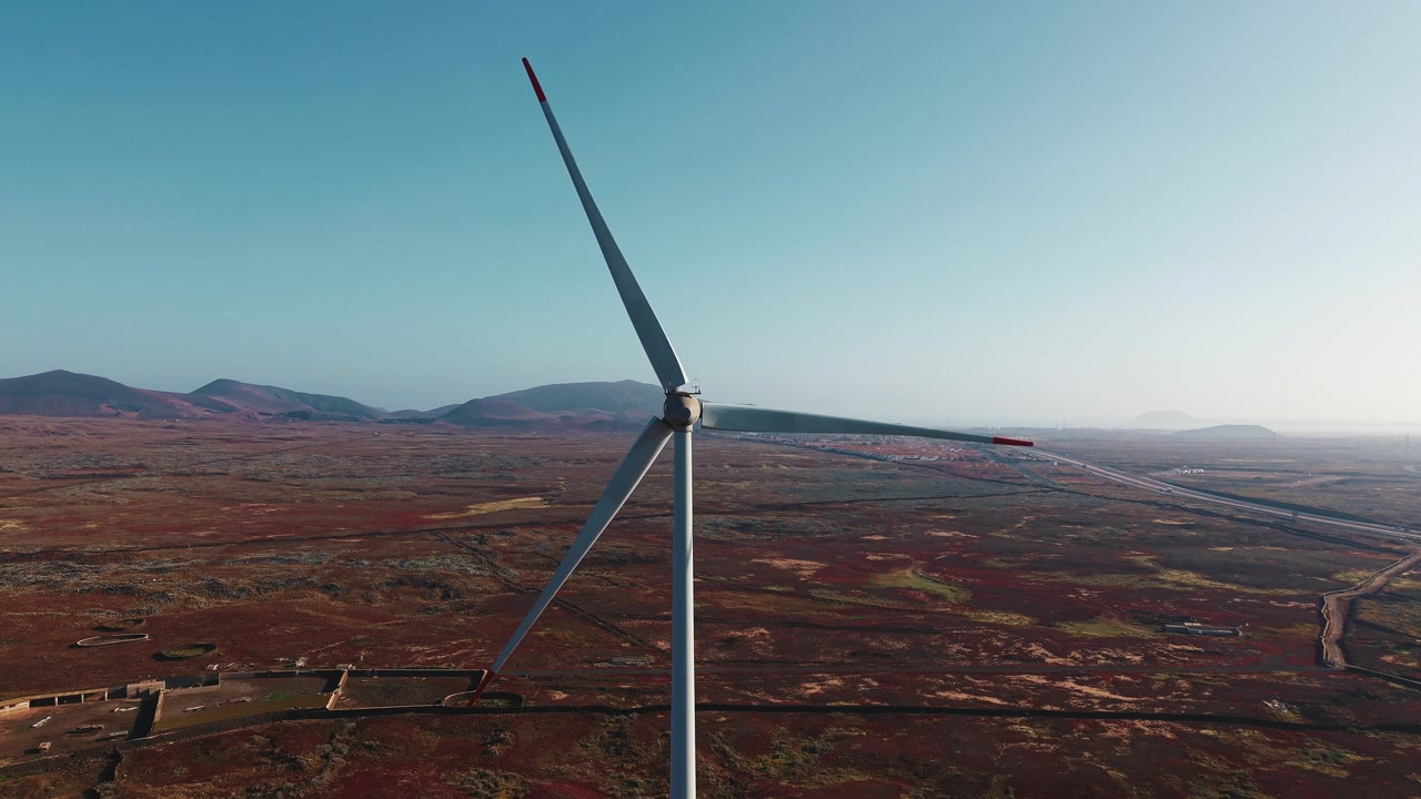 Turbina eolica in rotazione in un vasto paesaggio desertico