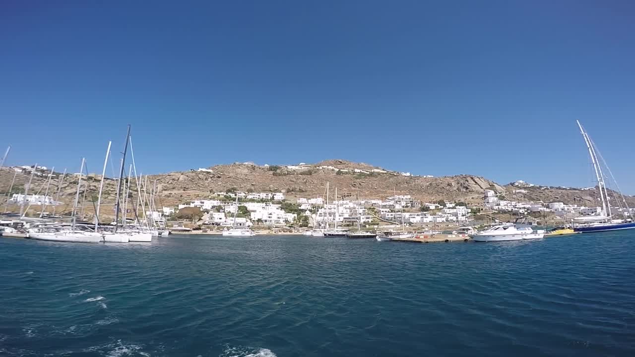 verano en la isla de mykonos, grecia con yates en el puerto y lujosas casas y hoteles frente al mar blanco