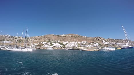 verano en la isla de mykonos, grecia con yates en el puerto y lujosas casas y hoteles frente al mar blanco