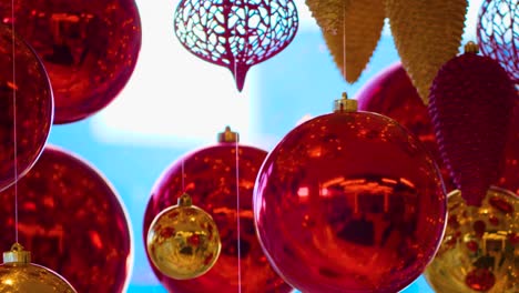 christmas and new year decoration. christmas big red balls on  background of luminous lanterns and gold garlands. holiday background. blinking garland. red baubles with lights twinkling close up.