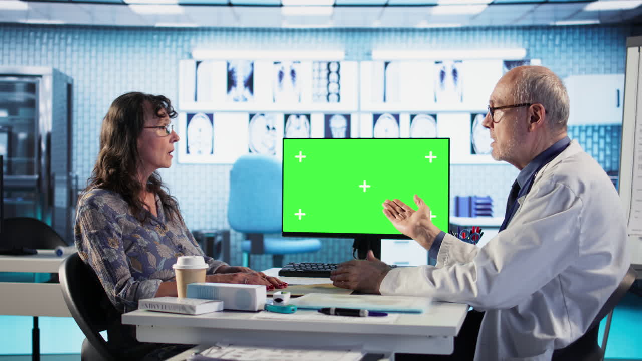 Vertical Video Elderly physician consulting patient lady next to isolated display in cabinet