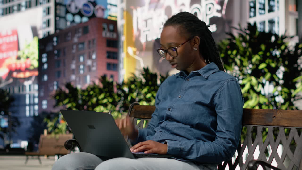 Stressed woman feeling burnout while using laptop on park bench