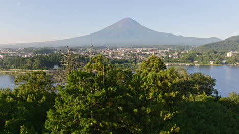 Aerial view rising over a island, revealing a town and Mt Fuji, summer in Japan