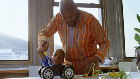 father and son repairing toy car in a comfortable home 4k