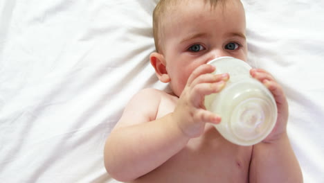 Süßes-Baby-Liegt-Und-Trinkt-Aus-Seiner-Babyflasche