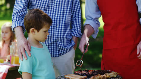 multi-generation family preparing food on barbecue