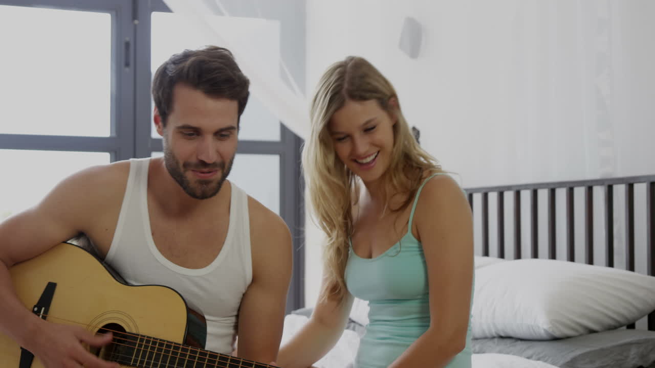 el novio tocando la guitarra en la cama