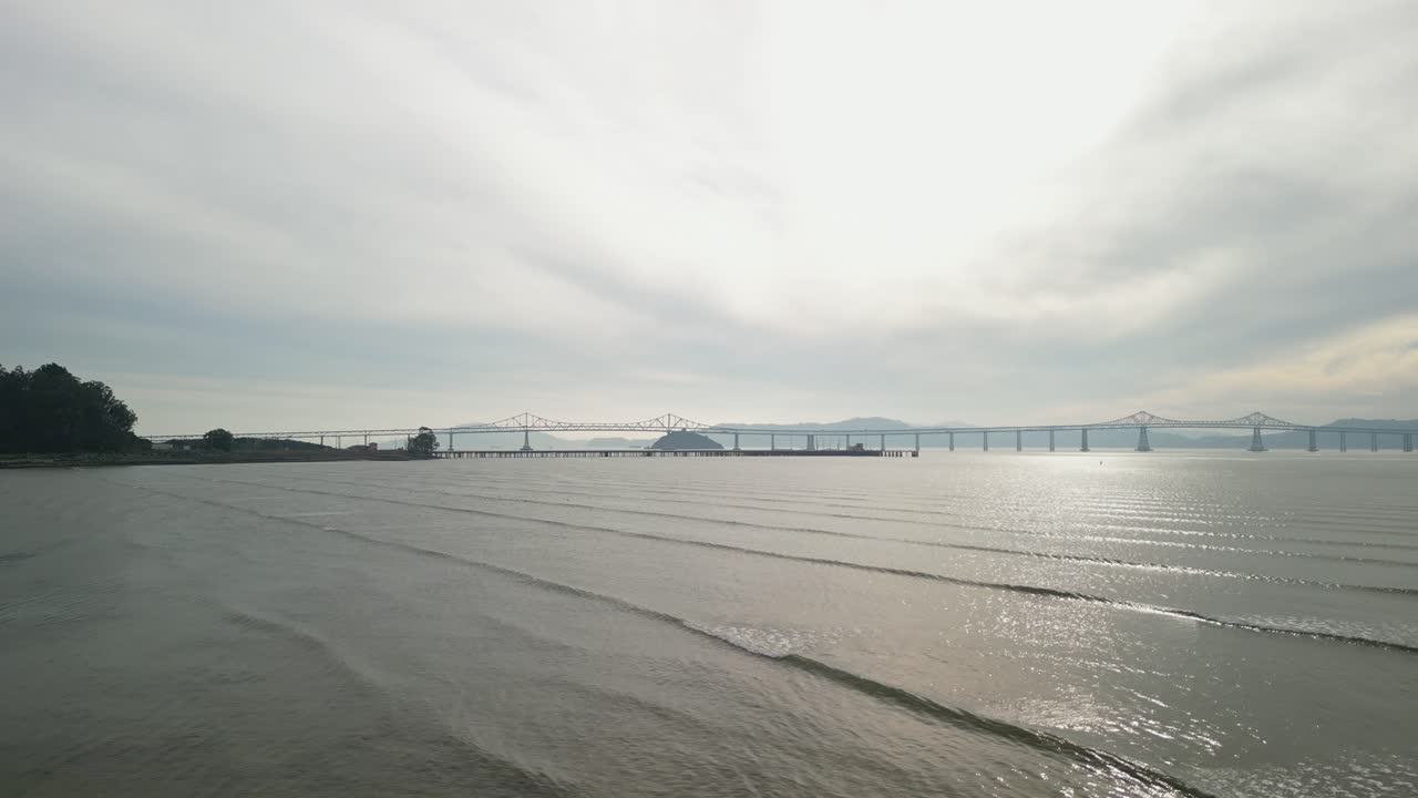 The Richmond–San Rafael Bridge, with its towering structure, rises above the bay near Point Molate Beach in Richmond.